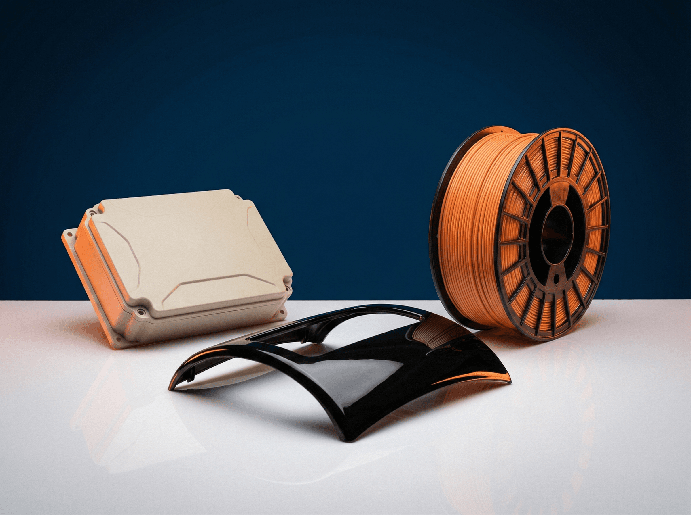 ABS products: glossy black automotive dashboard trim, beige electronics enclosure, and ABS 3D printing filament spool